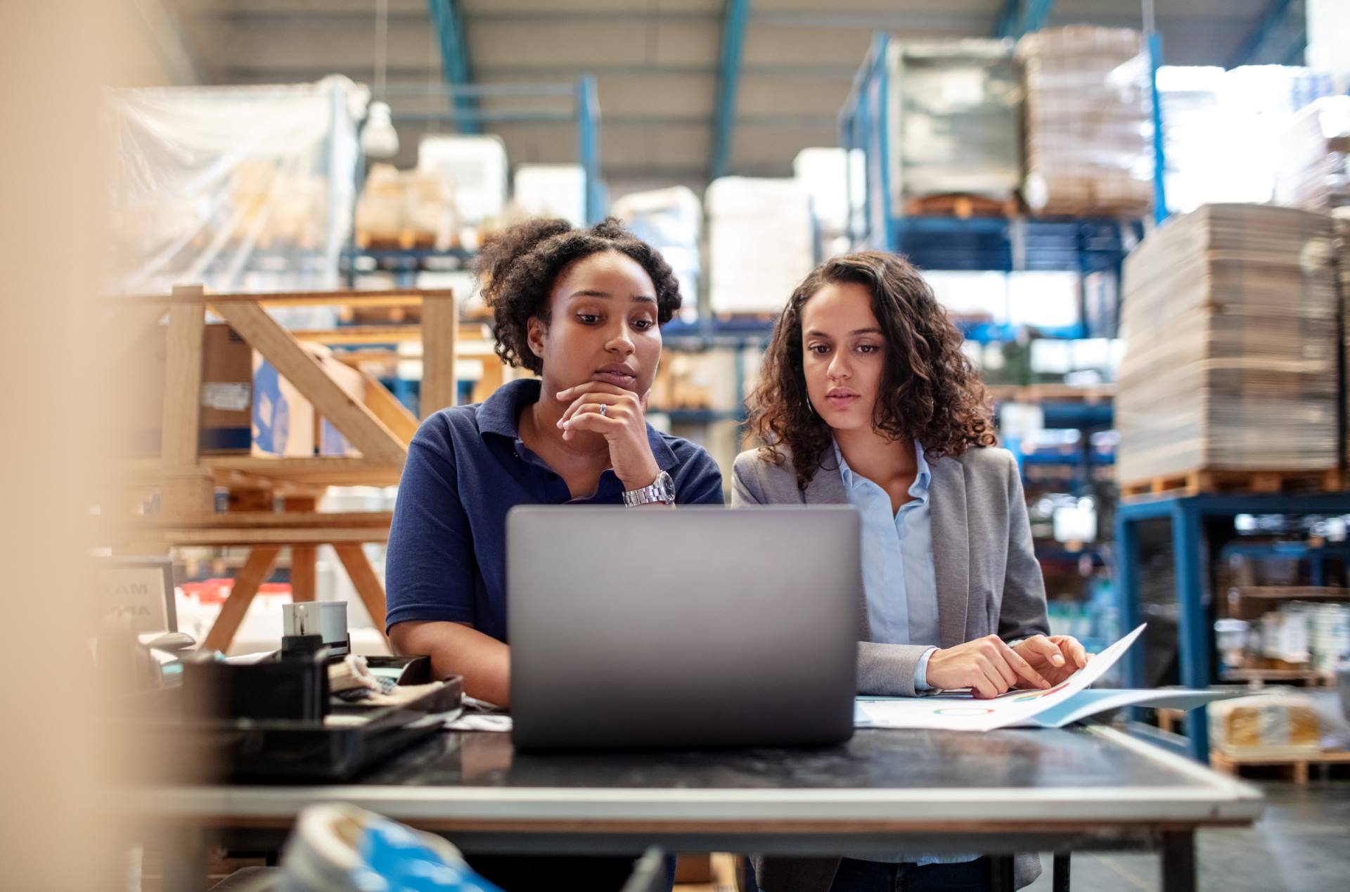 colleagues in warehouse review paperwork